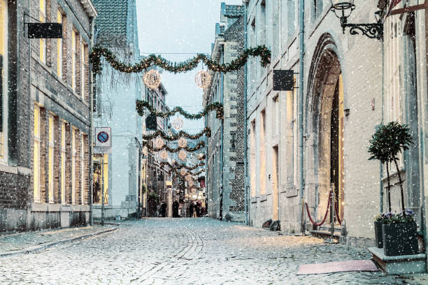 rue commerçante avec lumières de noël et de neige dans la ville néerlandaise de maastricht - christmas winter sunset snow photos et images de collection