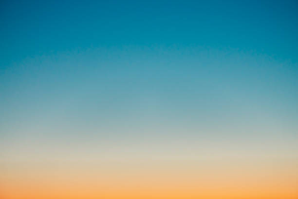 istock Predawn clear sky with orange horizon and blue atmosphere. Smooth orange blue gradient of dawn sky. Background of beginning of day. Heaven at early morning with copy space. Sunset, sunrise backdrop. 1072571370