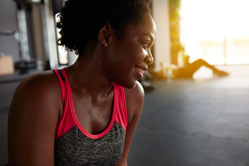 Group women on dancing on zumba class in the health club or gym. Focus on African woman resting after training.