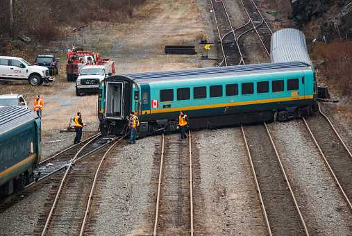 Halifax, Canada - November 25, 2018 - CN Rail workers survey damage to three VIA rail coaches after a derailment.  The train was enroute to the station and was empty at the time.