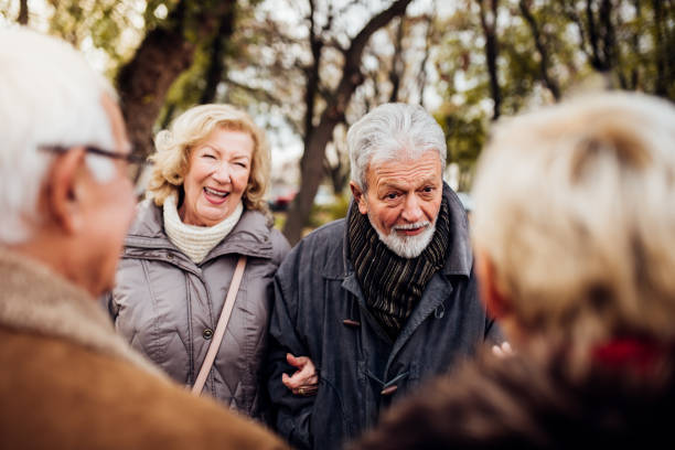 istock Two senior couples talking in the park 1072580424