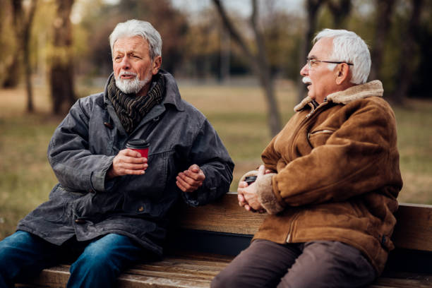 Senior men sitting on a bench in a park talking