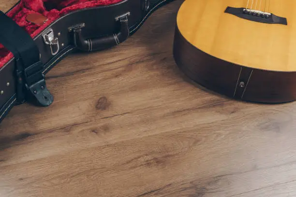 Photo of an acoustic guitar and leather guitar hard case