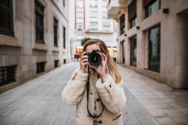 istock Young woman at city using a DSLR camera 1072586724