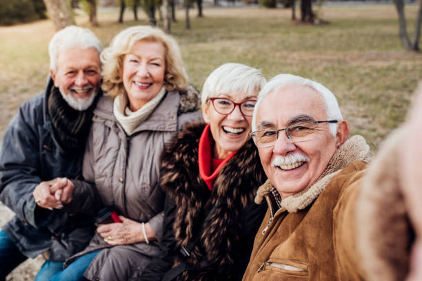 istock Two senior couples on a bench in a park 1072586866