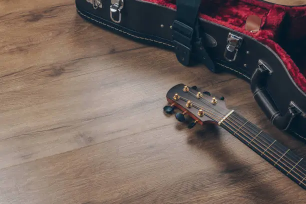 Photo of an acoustic guitar and leather guitar hard case