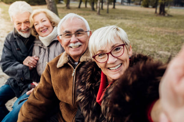 istock Happy senior couples on a bench in a park 1072587032