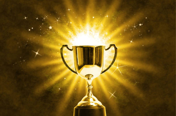 istock Winner trophy with abstract shiny light background 1072595360