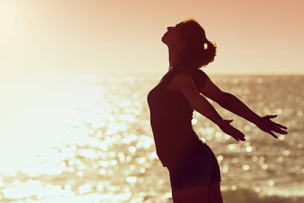 mujer relajante en cielo del atardecer de verano en la playa - milagro evento religioso fotografías e imágenes de stock
