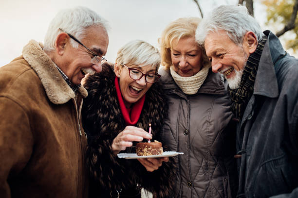 istock Two cheerful senior couples celebrating in the park 1072601376