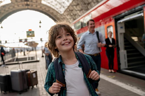 Happy boy traveling by train with his family â rail transportation concepts