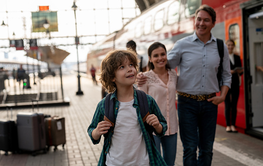 Happy boy traveling by train with his family â rail transportation concepts