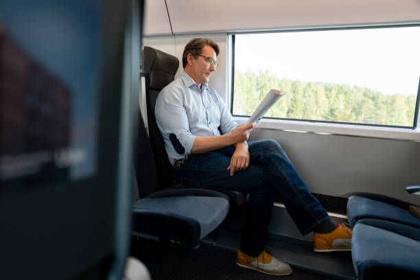 istock Man traveling by train and reading a travel guide 1072601572