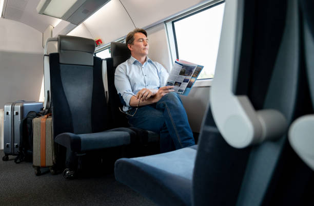 istock Man traveling by train and falling asleep reading a travel guide 1072601580