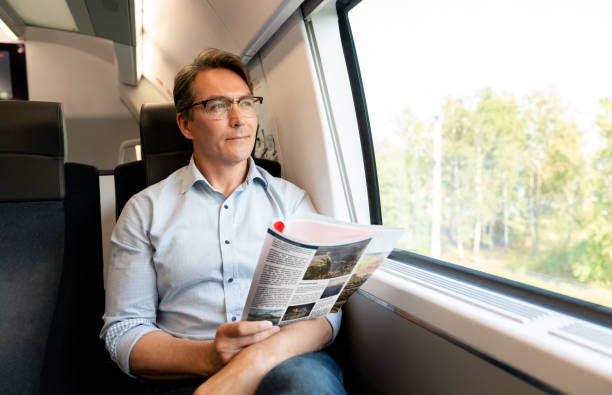 istock Man traveling by train and reading a travel guide 1072601600
