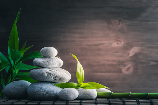 white zen  balance stones and bamboo plant on the wooden table