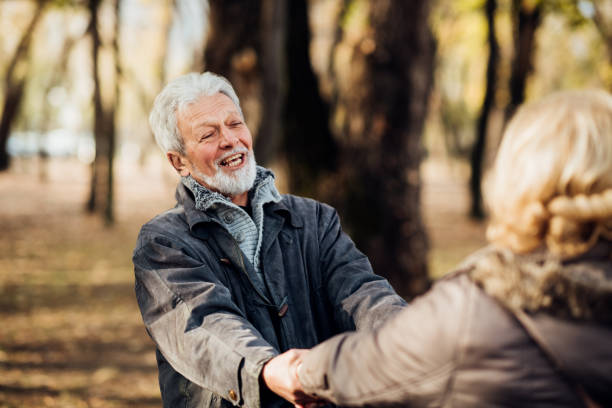 istock Smiling romantic senior couple holding hands in the park 1072604314