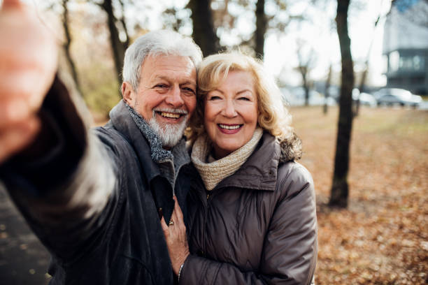 istock Senior couple smiling in the park taking a selfie 1072604538