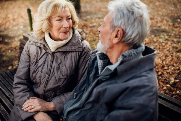 istock Senior couple sitting and talking in the park 1072604680