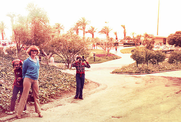 Vintage family making photos Vintage image of a mother and her children in a park taking pictures. 1980 photos stock pictures, royalty-free photos & images