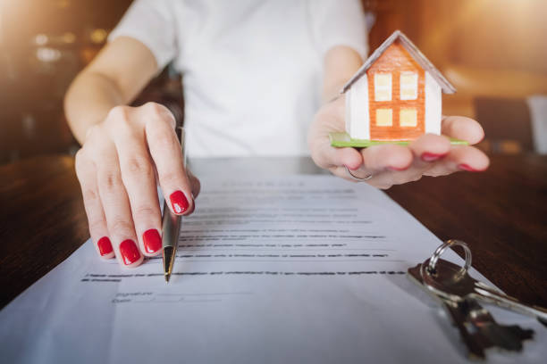 istock Contract documents, real estate agents Hold a pen indicating customers sign a contract to trade the house with the key. loan application concept. 1072607298