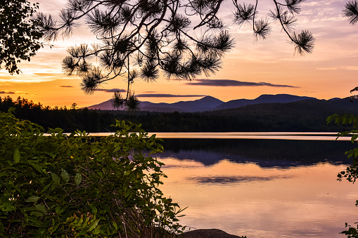 scenic nature of New Hampshire in the Northeast USA. Lake in the rays of the setting sun. Summer holidays in the USA