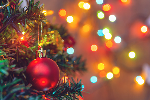 Decoración de la Navidad. Colgante bolas rojas en la guirnalda de Navidad árbol de ramas de pino y adornos sobre fondo abstracto bokeh con espacio de copia photo