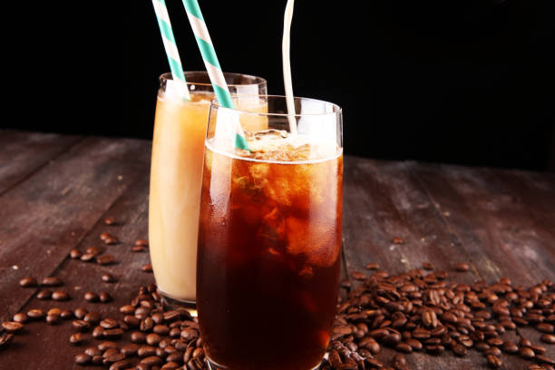 istock Ice coffee on a rustic table with cream being poured into it showing the texture and refreshing look of the drink 1072609026
