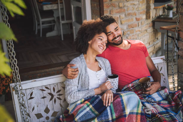 Morning coffee with husband on porch swing Couple drinking coffee in the morning on a porch early fall stock pictures, royalty-free photos & images