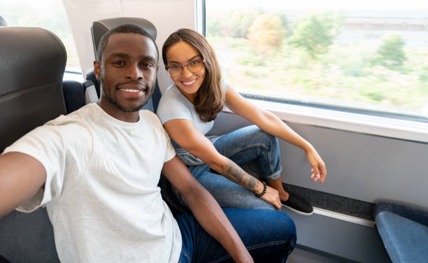 istock Happy couple traveling by train and taking a selfie 1072612366