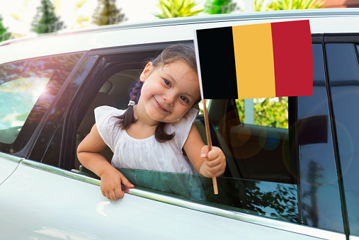 Girl holding Belgian Flag in the car.