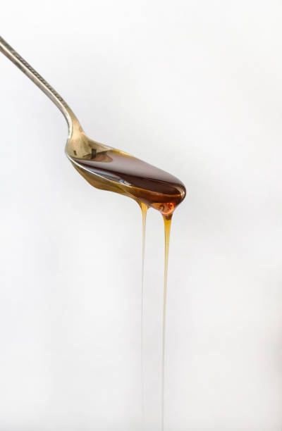 istock close-up silvery and vintage spoon with honey falling, on white background 1072623860
