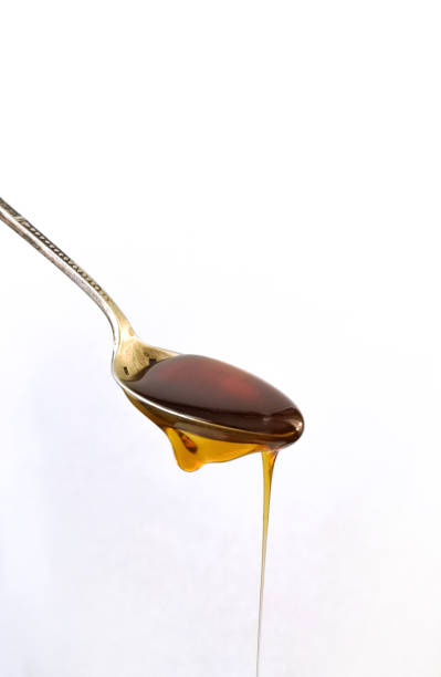 istock close-up silvery and vintage spoon with honey falling, on white background 1072623932
