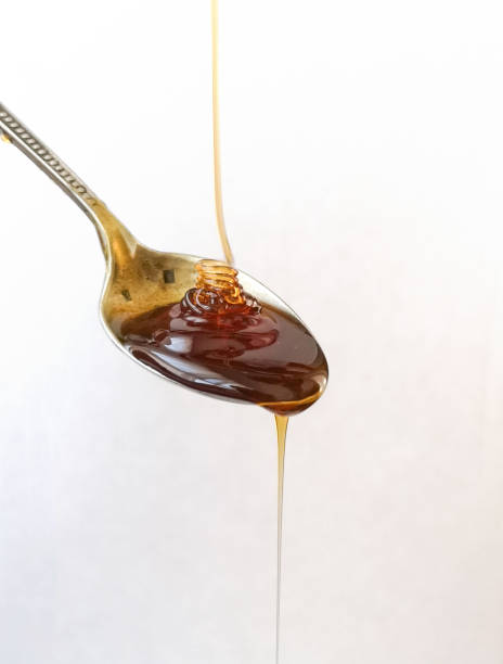 istock close-up silvery and vintage spoon with honey falling, on white background 1072625006