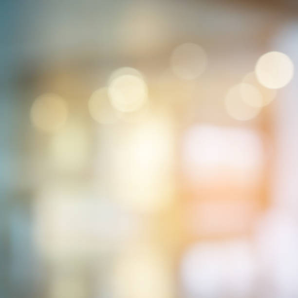 abstract blurred inside shopping mall with orange color light warm tone and bokeh background for design element concept