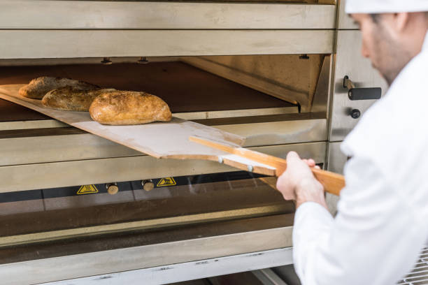istock Male baker taking out freshly baked bread 1072635494