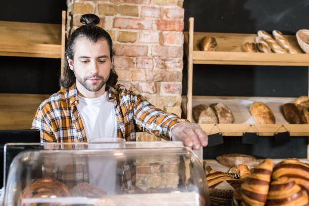 istock handsome adult seller working at bakery 1072635592