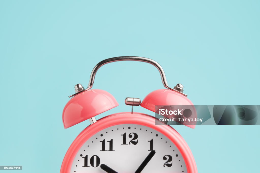 Red alarm clock on blue background Time Stock Photo