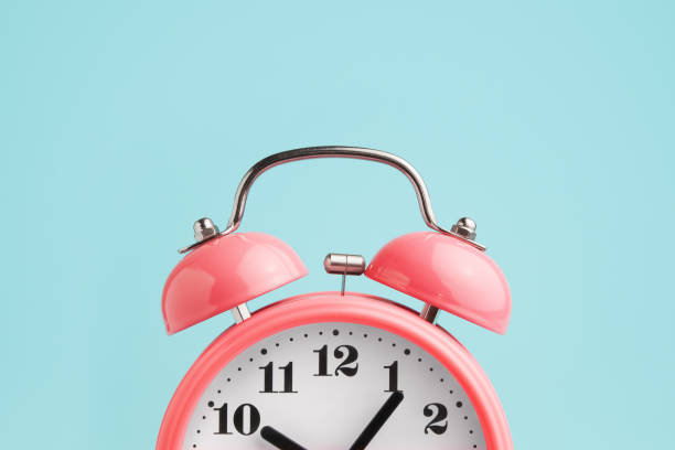 red alarm clock on blue background - deadline imagens e fotografias de stock