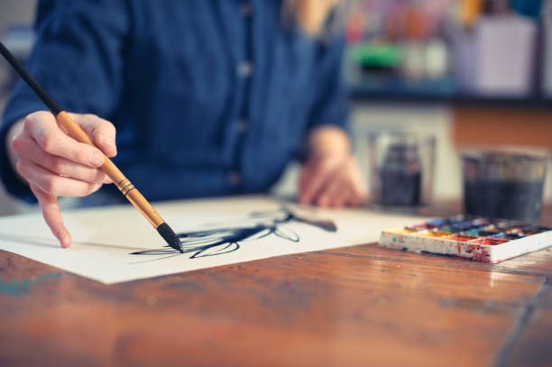 istock Young Woman Artist Working On Painting In Studio. Selective focus on foreground. 1072642028