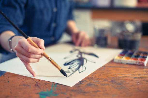istock Young Woman Artist Working On Painting In Studio. Selective focus on foreground. 1072642046