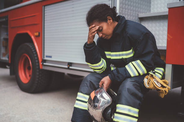 Depressed firefighter after rescue operation Unhappy firefighter sitting at the firefighter truck after failure on rescue operation face down stock pictures, royalty-free photos & images