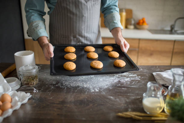 istock Pastry chef holding cooking pan with baked cookies 1072654032