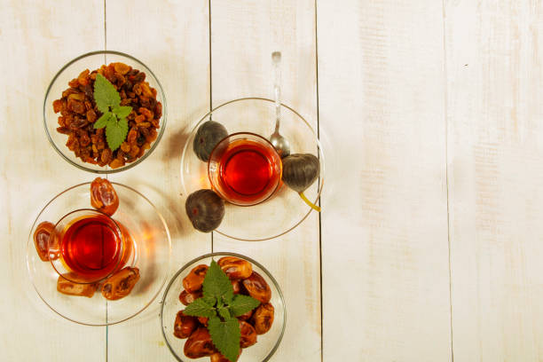 istock A cup of tea on a white table.Traditional Arabic, Turkish Ramadan tea with dry dates and raisins on a wooden white table. Turkish fresh tea with dates. Ramadan kareem. Ramadan background. 1072654744