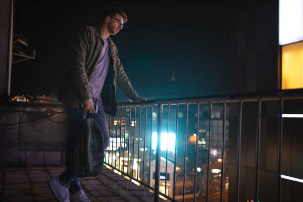 istock Sad and depressed modern hipster looking at a city from a rooftop 1072658274