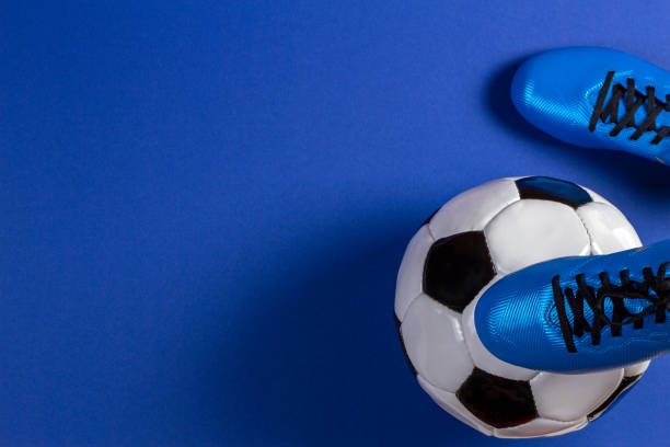 ballon de soccer sous les pieds de joueurs de football sur fond bleu - football ball isolated sport photos et images de collection