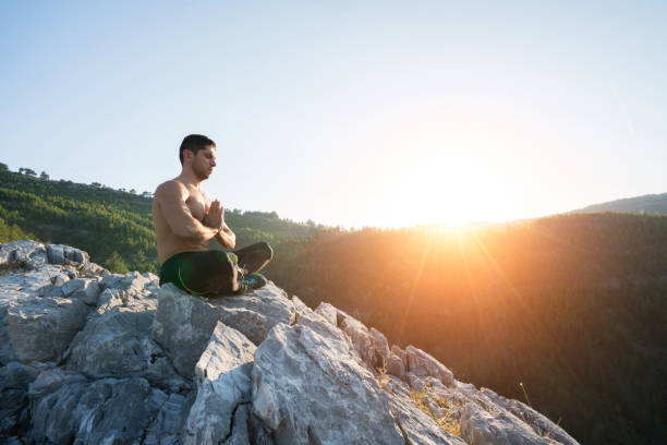 istock Man meditating yoga at sunset mountains 1072660578