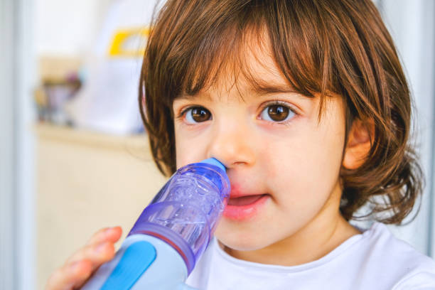 bebê resfriado leva lavagens nasais com dispositivo de irrigação de nariz - nasal cavity - fotografias e filmes do acervo