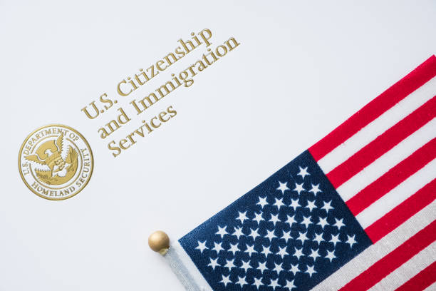 top/u.s。 移民コンセプトにアメリカ国旗を持つ米国市民権・移民局から封筒 - 税関 ストックフォトと画像