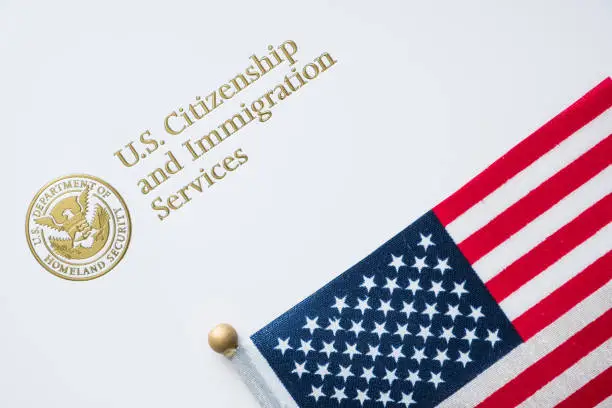 Photo of Envelope from U.S. Citizenship and Immigration Services with the American flag on top/U.S. immigration concept
